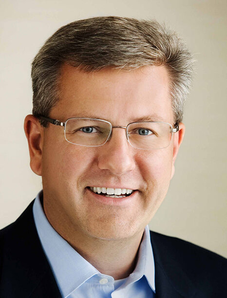Close up, smiling man in suit wearing glasses